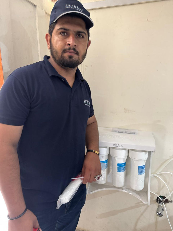 INTELLI technician beside a newly installed water purification unit